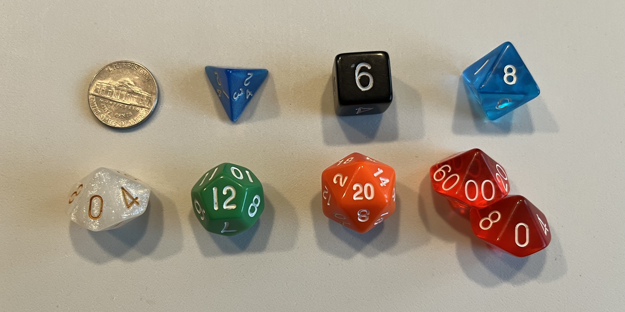 A coin, d4, d6, d8, d10, d12, d20, and pair of d10s as a d100.